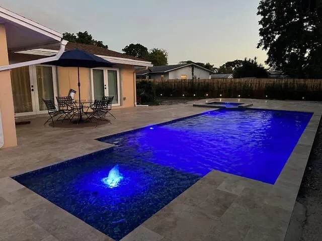 Modern geometric L-shaped pool and custom inground spa in Miami-Dade by Bluewater Design Studio
