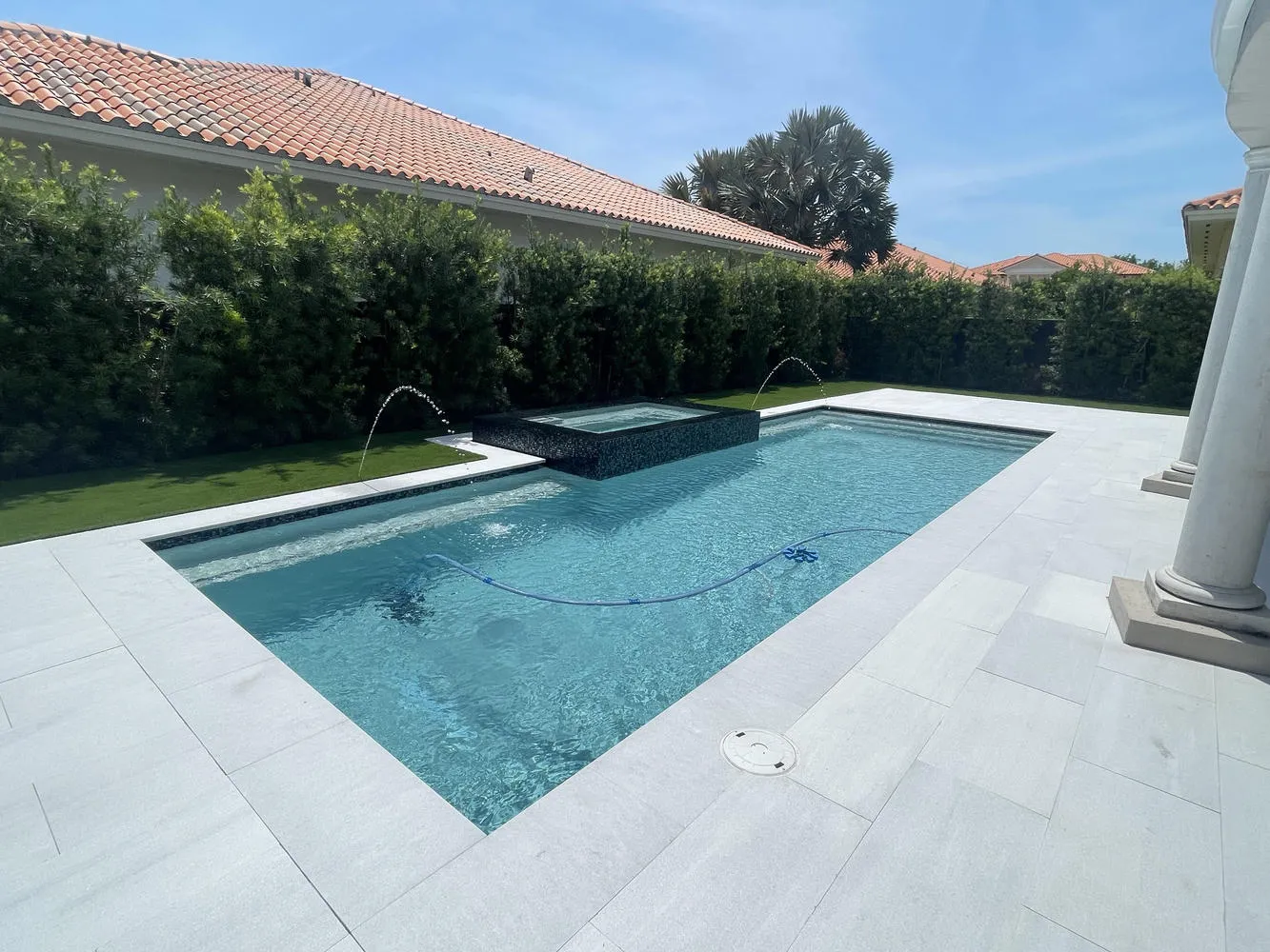 Modern geometric inground pool and integrated spa in Cutler Bay by Bluewater Design Studio