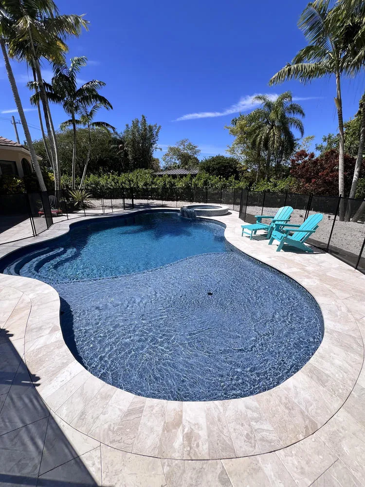 Custom freeform inground pool and integrated spa in Palmetto Bay by Bluewater Design Studio