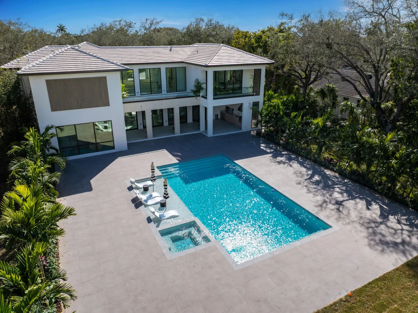 Modern estate geometric pool with integrated sun shelf and spa complex in Miami-Dade by Bluewater Design Studio